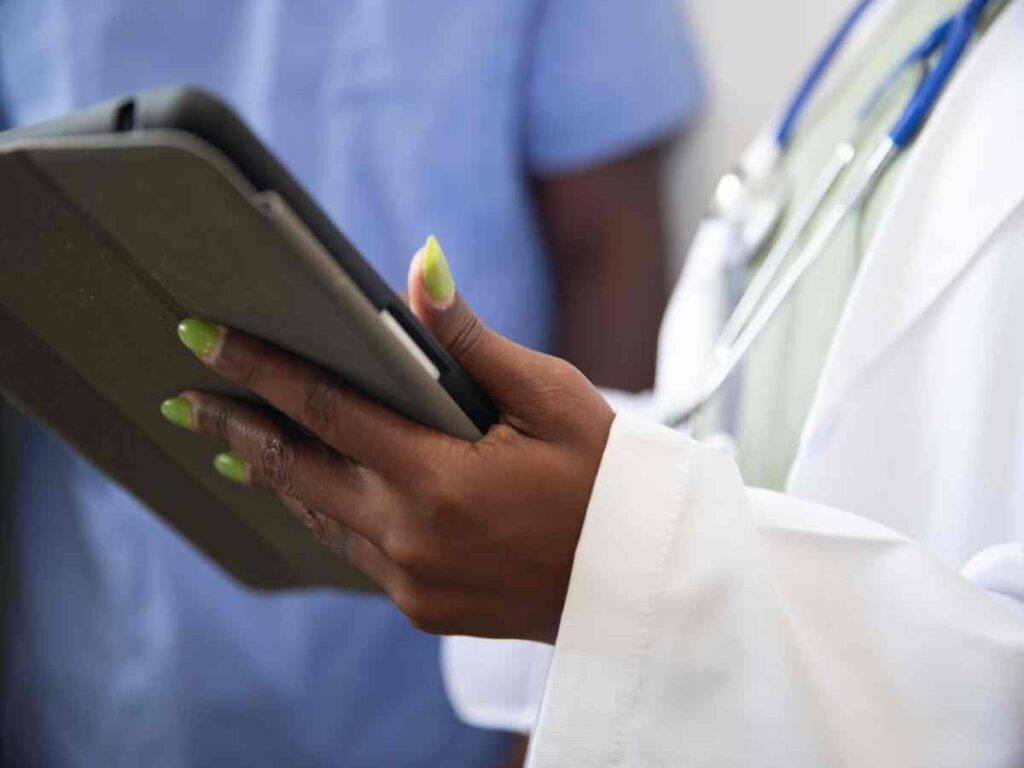 A healthcare professional with a tablet, focusing on key features of HIPAA-compliant fax services.